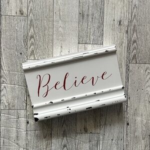 Quill To Paper White and Red 'Believe' sign